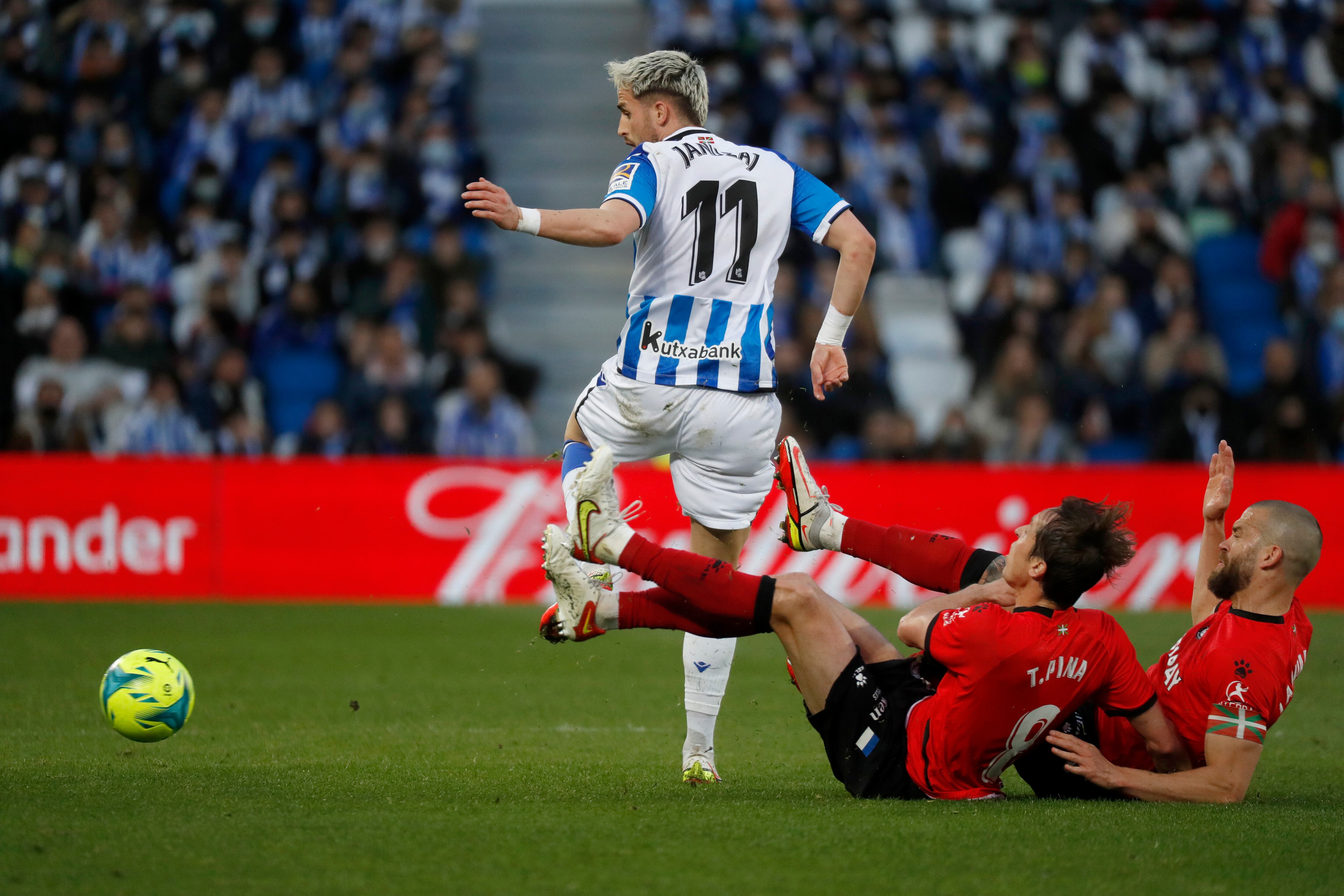 SAN SEBASTIÁN, 13/03/2022.- El centrocampista belga de la Real Sociedad, Adnan Januzaj (i), intenta salvar la entrada de los jugadores del Alavés, Tomás Pina y Victor Laguardia (d), durante el encuentro correspondiente a la jornada 28 de primera división disputado hoy Domingo en el Reale Arena de San Sebastián. EFE / Javier Etxezarreta.
