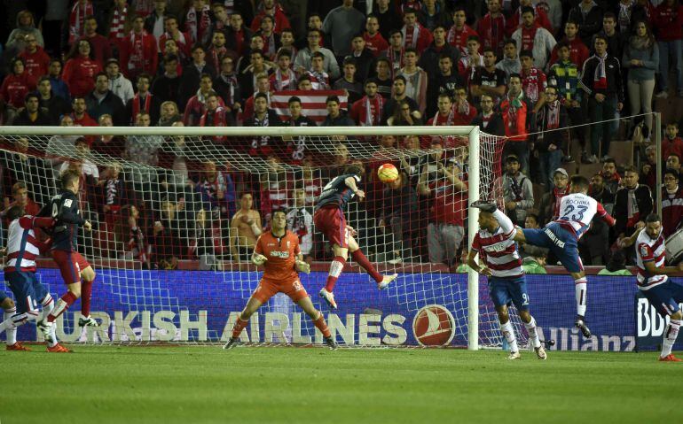 El defensa uruguayo del Atlético de Madrid Diego Godín bate al portero del Granada, Andrés Fernández