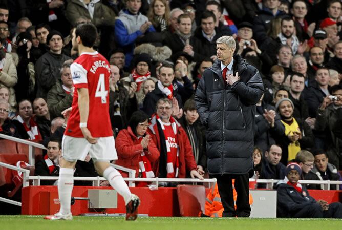 El entrenador Arsene Wenger del Arsenal observa al jugador Cesc Fabregas, quien sale del juego por una lesión en el partido contra el Stoke City durante un partido de la Premier League inglesa