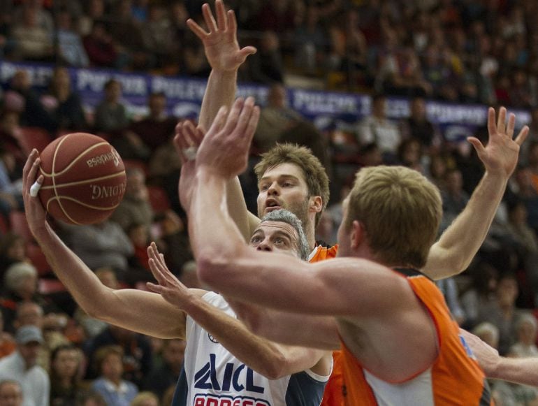 El escolta del ICL Manresa Román Montañés (i) entra a canasta ante los jugadores del Valencia Basket Jon Stefansson (i) y Luke Sikma (d), durante el partido de la vigésima tercera jornada de Liga ACB, disputado hoy en el pabellón Fuente de San Luis, en Va