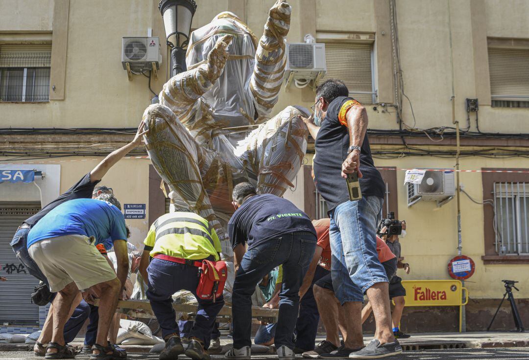 Varias personas participan en la descarga de la falla de Jacinto Labaila, en el barrio de Patraix de la ciudad de Valencia. 