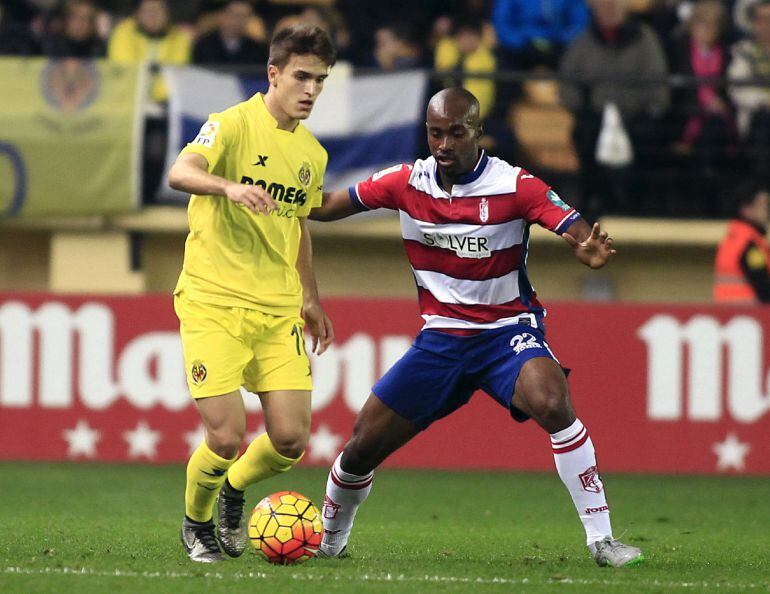 El defensa francés del Granada, Dimitri Foluquier (d), disputa un balón con el centrocampista del Villareal Denis Suárez