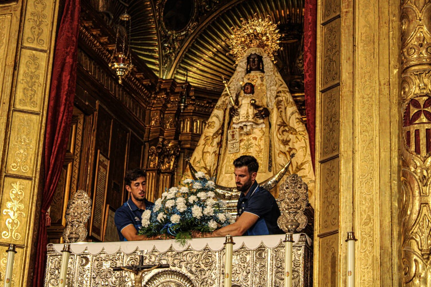 Antonio Oca y Marcelo colocando las flores ante la Patrona