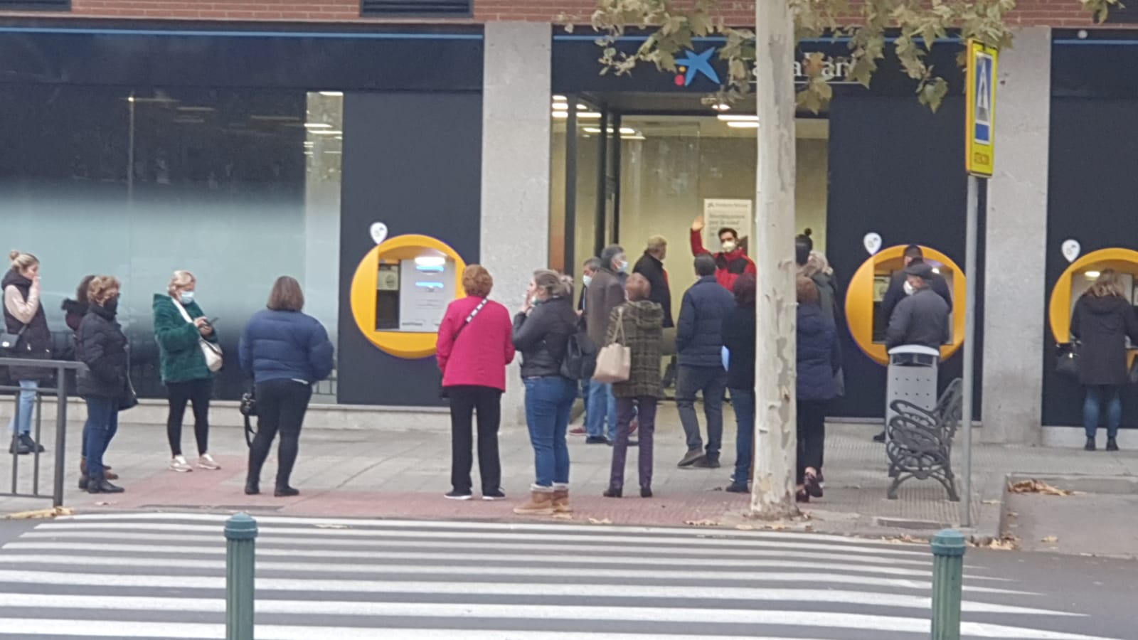 Clientes de Caixabank aguardan su turno en el exterior de la entidad