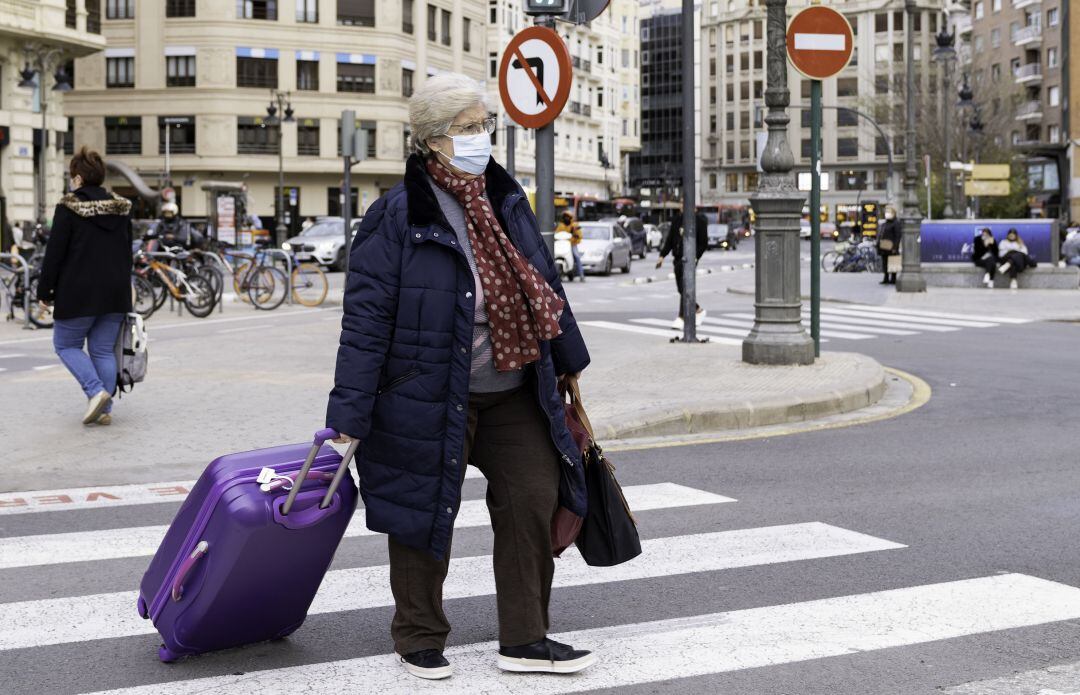 Una persona camina por la calle Xàtiva de València. 