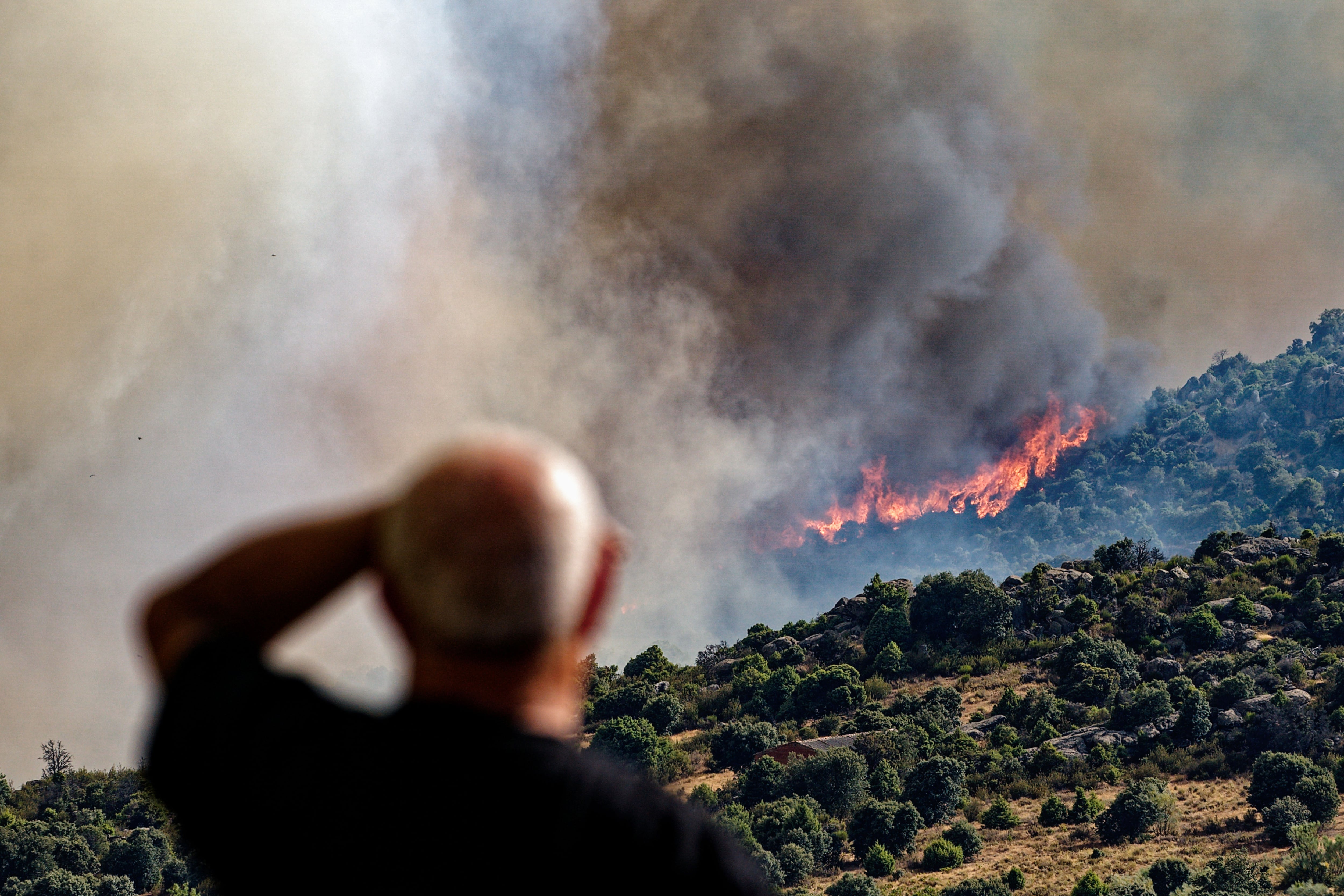 NAVALUENGA (ÁVILA), 18/07/2025.- Un hombre contempla un incendio forestal declarado en el término municipal de Navaluenga (Ávila), este viernes. EFE/ Raúl Sanchidrián
