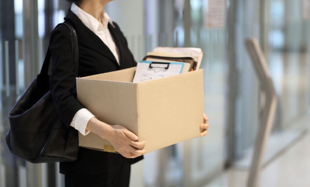 Una mujer lleva una caja.