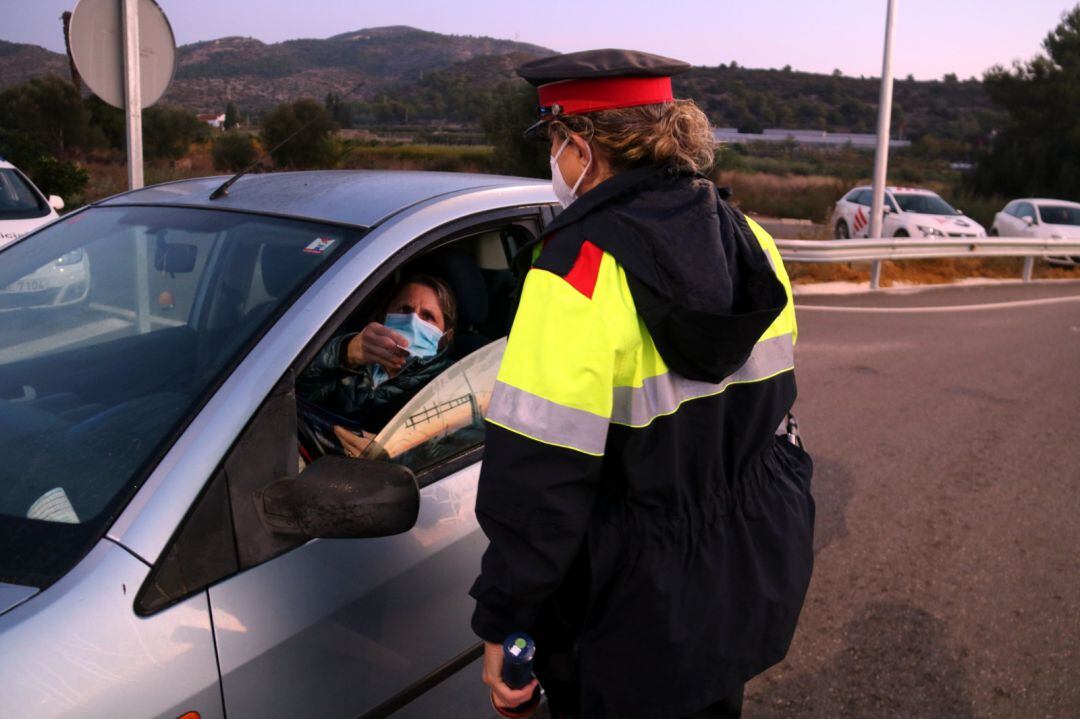 Pla mitjà d&#039;una agent dels Mossos comprovant la identitat d&#039;una conductora en els controls de mobilitat que s&#039;han fet a Alcanar.