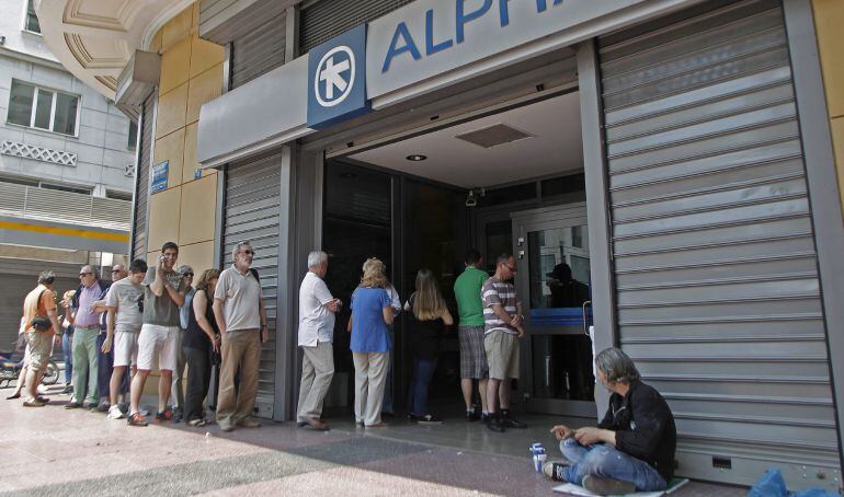 . Athens (Greece), 28/06/2015.- People wait in a queue to withdraw money from an ATM outside a branch of Greece&#039;s Alpha Bank in Athens, Greece, 28 June 2015. Greek Prime Minister Alexis Tsipras called for a referendum on the Greek debt deal on 05 July, du