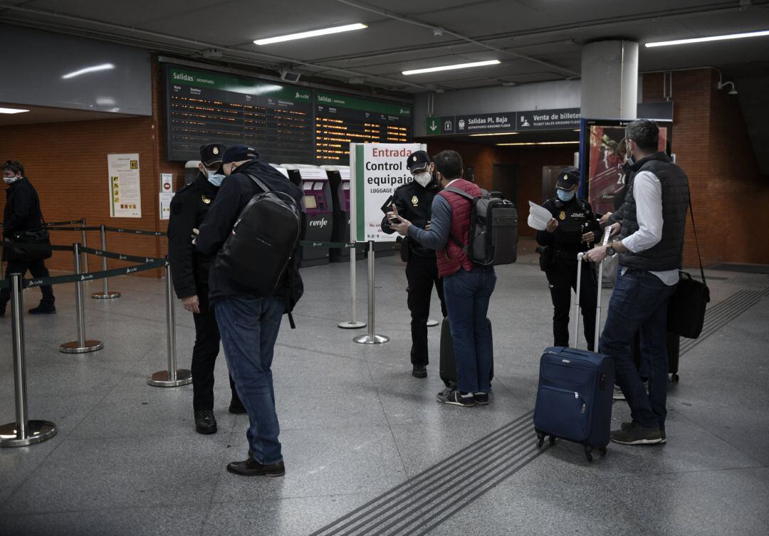 Varios agentes de Policía Nacional piden documentación a pasajeros en la estación de Atocha, en Madrid.