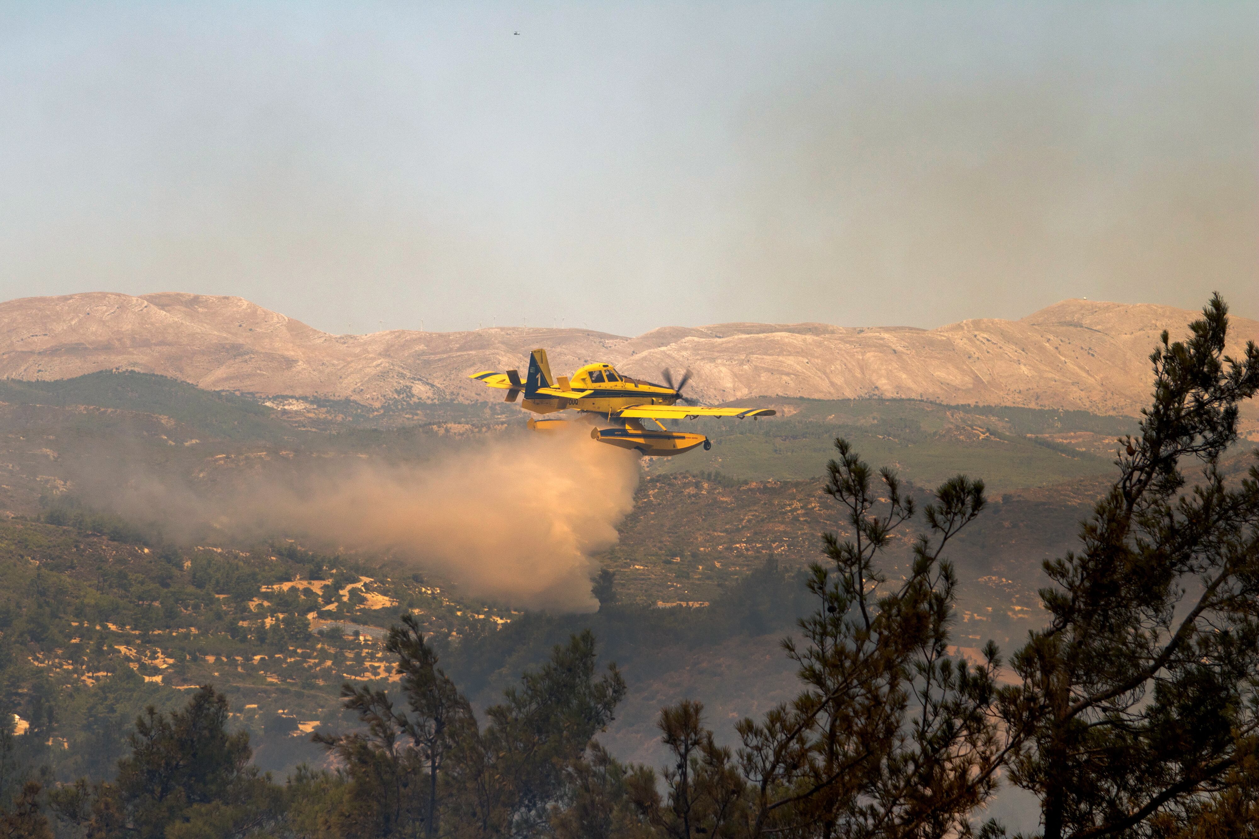 Una avioneta descarga agua sobre el incendio de la isla griega de Rhodes.