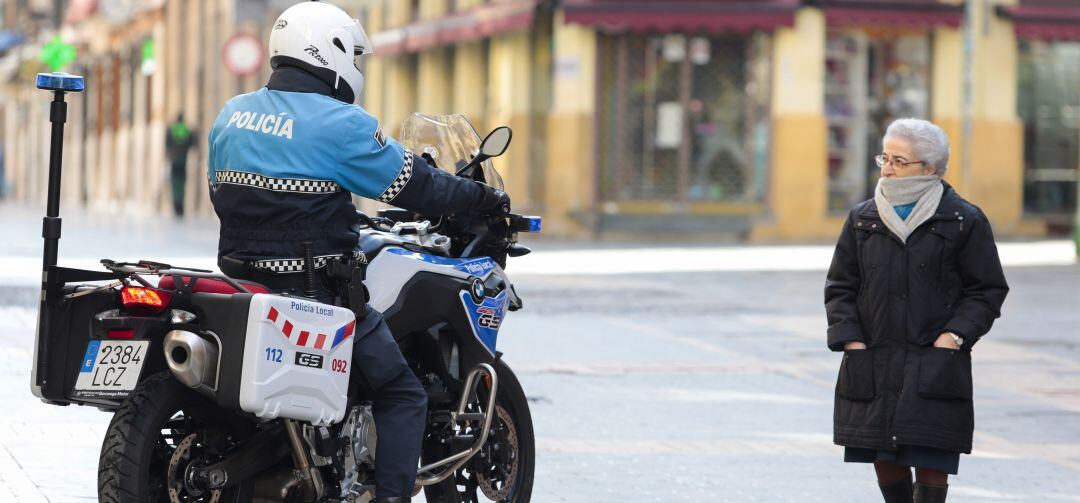 Un agente de la Policía Local de León conversa con una mujer