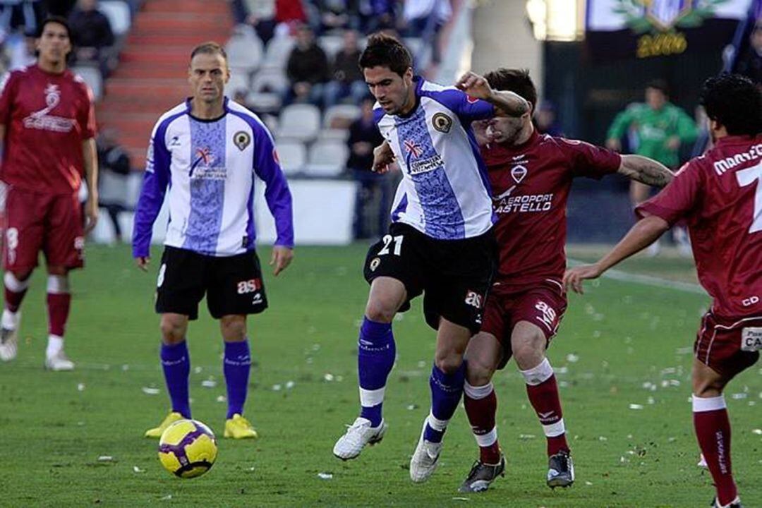 Dani Bautista controla el balón ante la mirada de Farinós