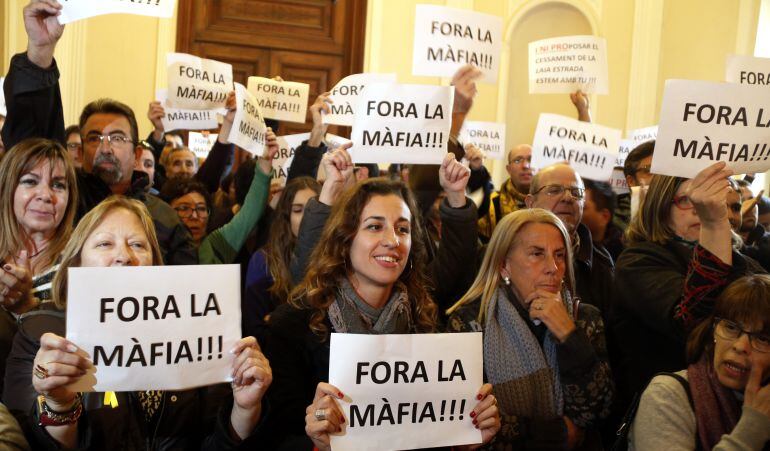 Pla obert de la regidora de la CUP de Tarragona Laia Estrada -al centre-, rebent el suport de diverses persones a l'exterior del saló de plens, mostrant cartells amb la frase 'Fora la màfia'.