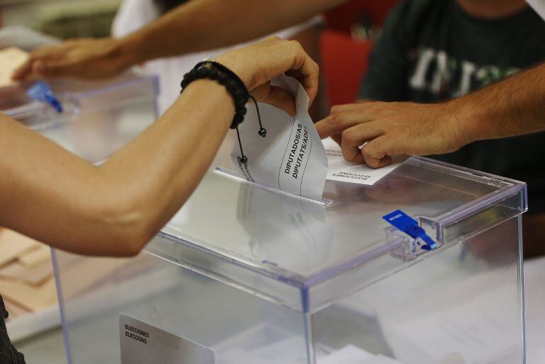 Una persona deposita su voto en un colegio de Barcelona.Más de 36,5 millones de votantes decidirán hoy en las elecciones generales el reparto de los 350 escaños del Congreso de los Diputados y los 208 del Senado durante la próxima legislatura