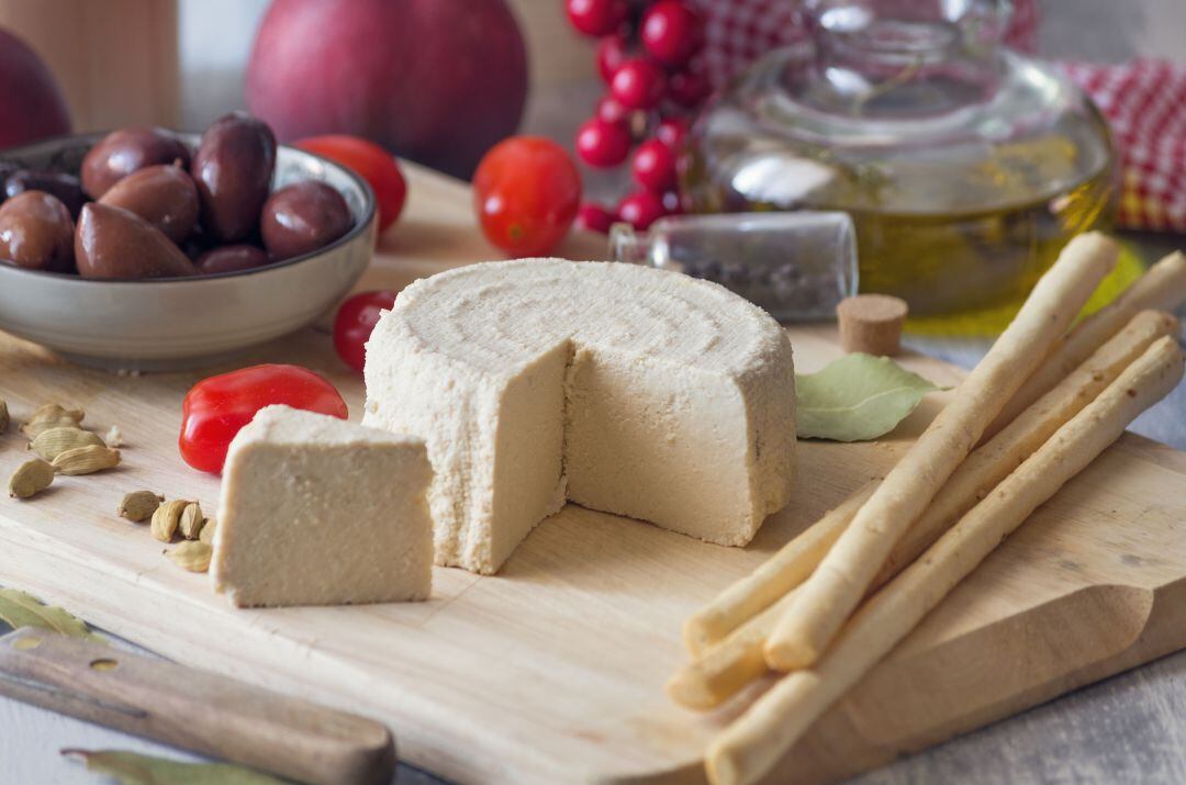 Imagen de archivo de un queso fresco sobre una tabla de madera.