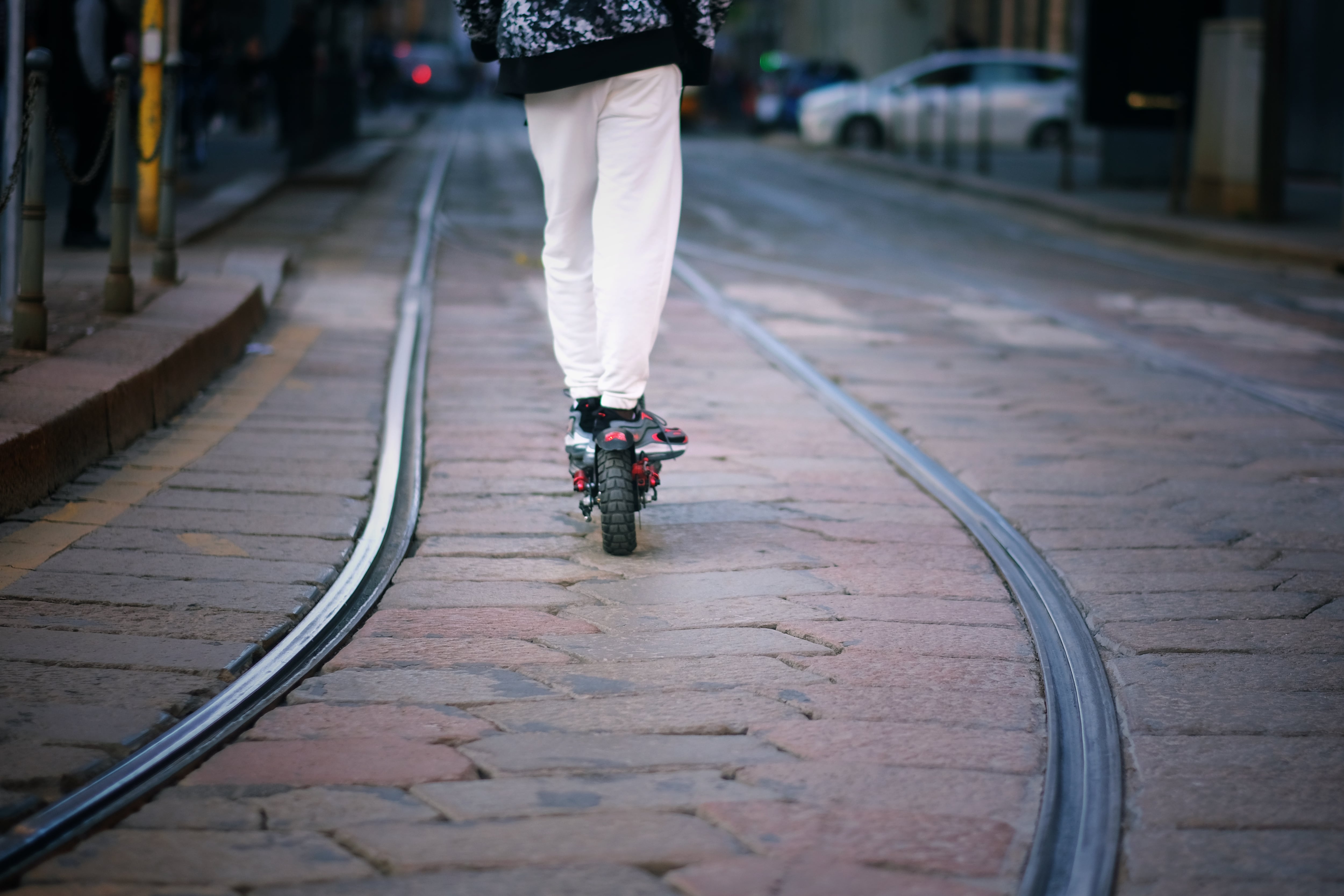 Un patinete circulando entre las vías del tranvía