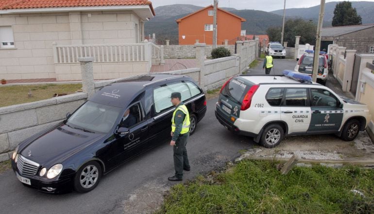 Un vehículo de la funeraria ante la casa de Santa María de Xuño, en la parroquia de Porto do Son (A Coruña), donde han sido localizados los cuerpos sin vida de un hombre y de una mujer