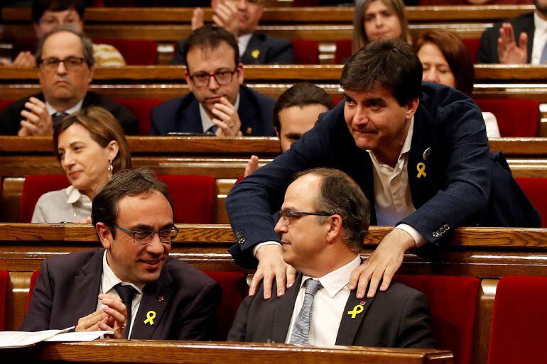 El portavoz de ERC, Sergi Sabrià (d) saluda tras su discurso en el debate de investidura al candidato de JxCat, Jordi Turull