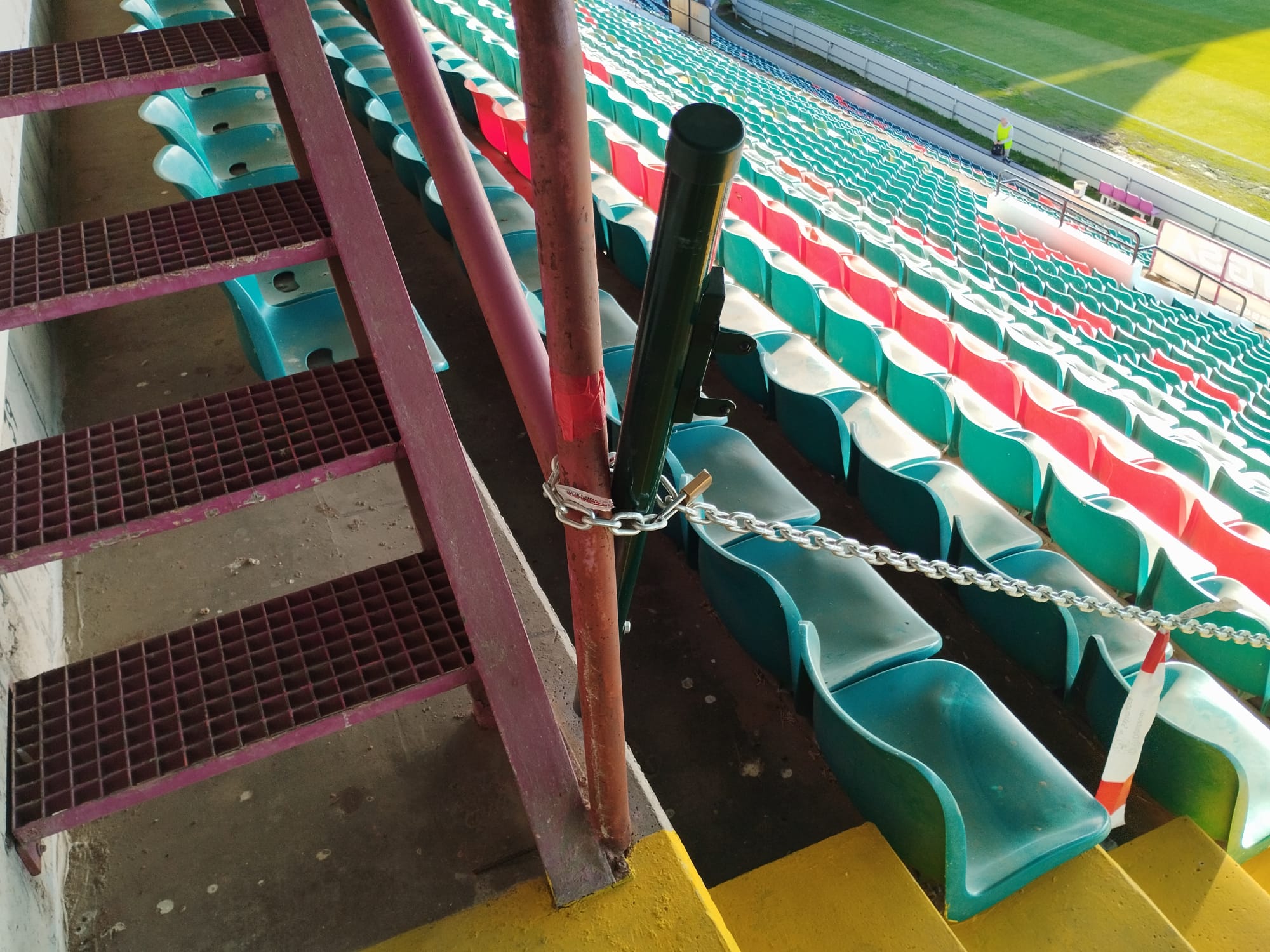 La nueva puerta para separar la zona de prensa de la grada, sin los anclajes fijados y con una cadena que atraviesa toda la grada/SER