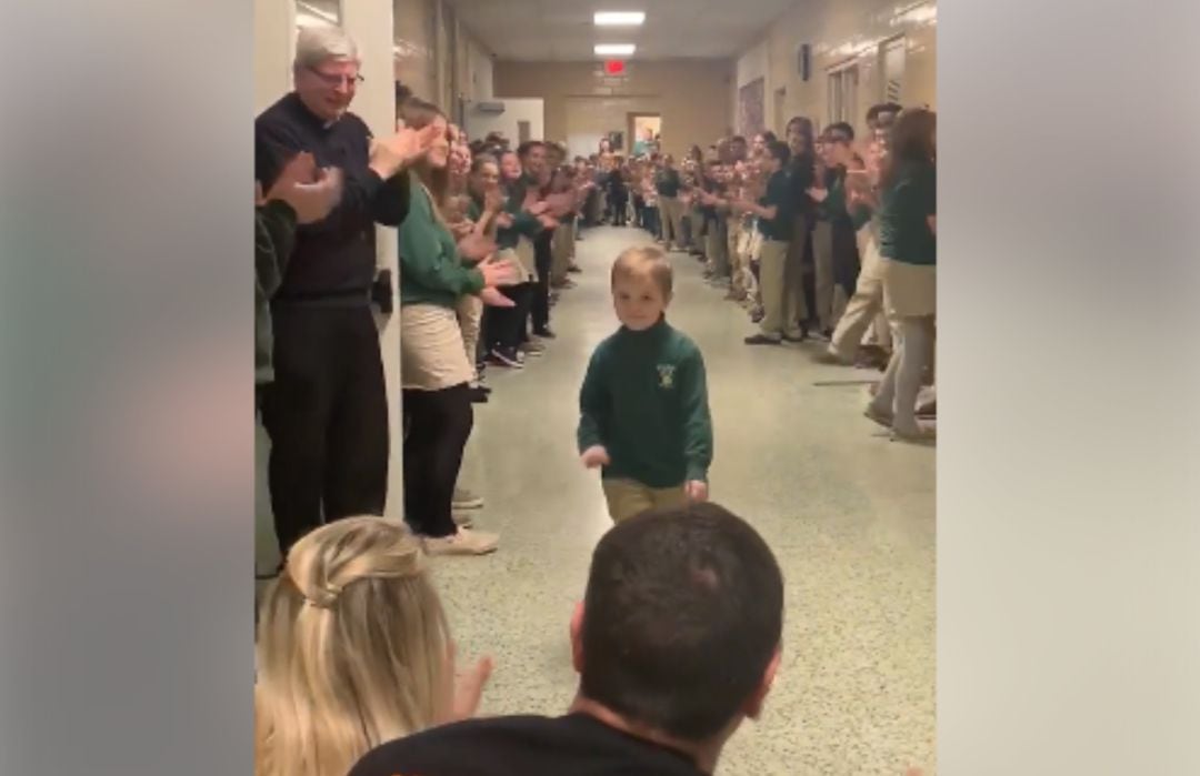 Imagen del momento en que John Oliver Zippay es recibido en su colegio entre aplausos.