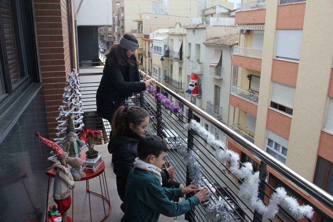 La regidora de Fira i Festes, Àngels Muñoz, engalana els balcons junt a familiars