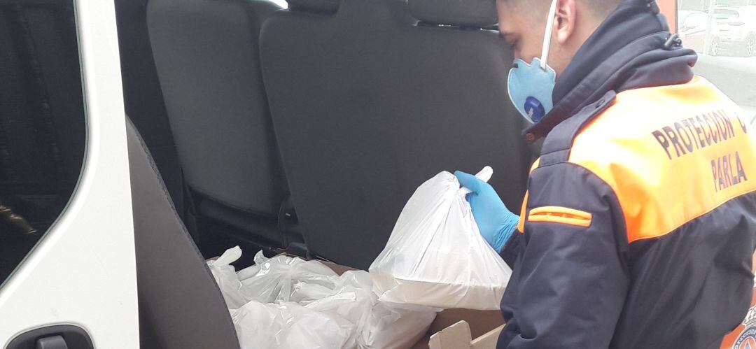 Uno de los miembros de Protección Civil con raciones de comida