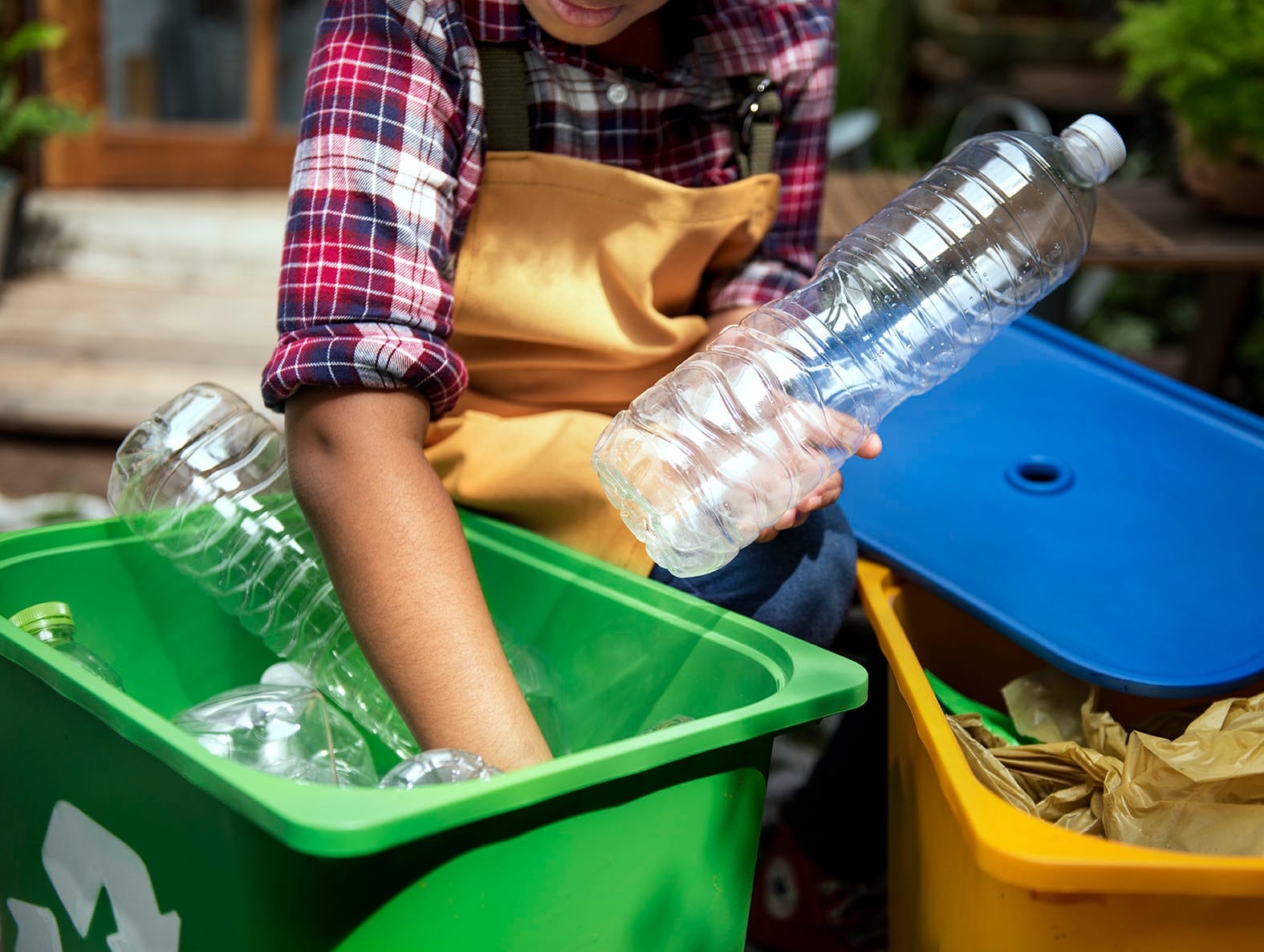 Una mujer recicla una botella de plástico.