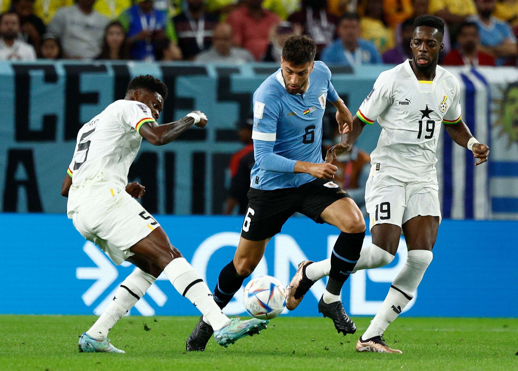 Thomas Partey (i) y Iñaki Williams (d) de Ghana disputa un balón con Rodrigo Bentancur de Uruguay hoy, en un partido de la fase de grupos del Mundial de Fútbol Qatar 2022 entre Ghana y Uruguay en el estadio Al-Janoub, en Al-Wakrah (Catar). EFE/Rodrigo Jiménez