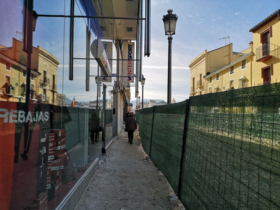 Poco más de un metro separa las vallas que limitan las obras con la puerta de entrada de los negocios de esta zona