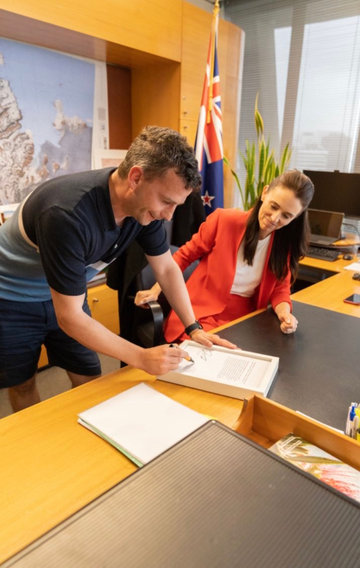 Jacinda Ardern y David Seymour firman una copia del diario de sesiones que recogió el insulto (&quot;capullo arrogante&quot;) con el objetivo de recaudar dinero para la Fundación de Cáncer de Próstata