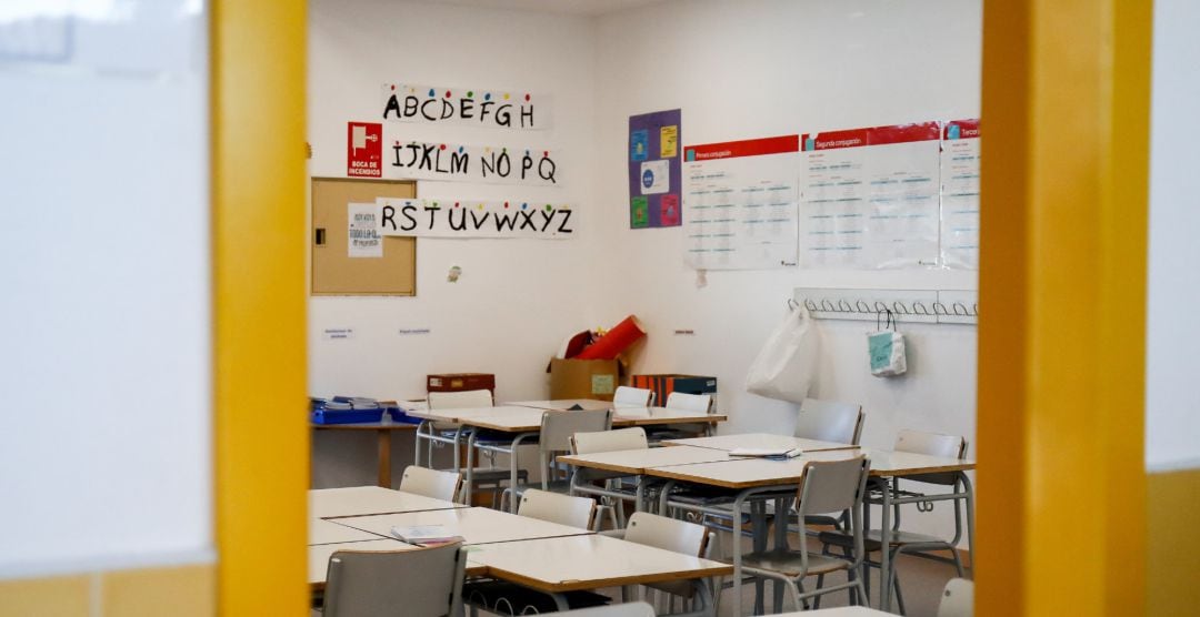 Sillas y mesas de un aula en el interior de un colegio