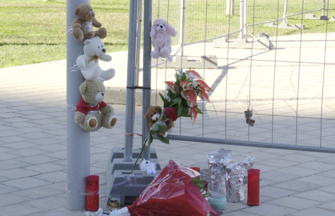 Flores, peluches y velas en el vallado de la Feria de Mislata