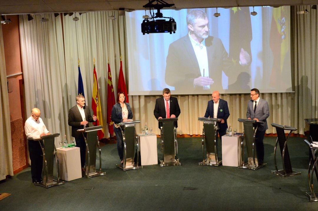 Los candidatos a presidir la Región de Murcia confrontan ideas en el debate electoral de La Opinión. A la derecha el atril vacío del candidato del PP, Fernando López Miras, que ha declinado su invitación