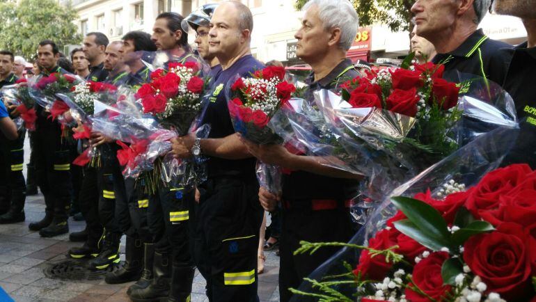 Representantes de las unidades de bomberos hacen la ofrenda