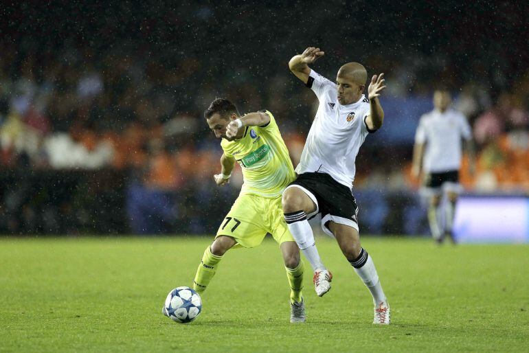 GRA427. VALENCIA, 20/08/2015.- El jugador del Valencia Feghouli (d) pela un balón con Milicevic, del Gante, durante el partido de la tercera jornada de la fase de grupos de Liga de Campeones que se juega esta noche en el campo de Mestalla, en Valencia. EFE/Manuel Bruque