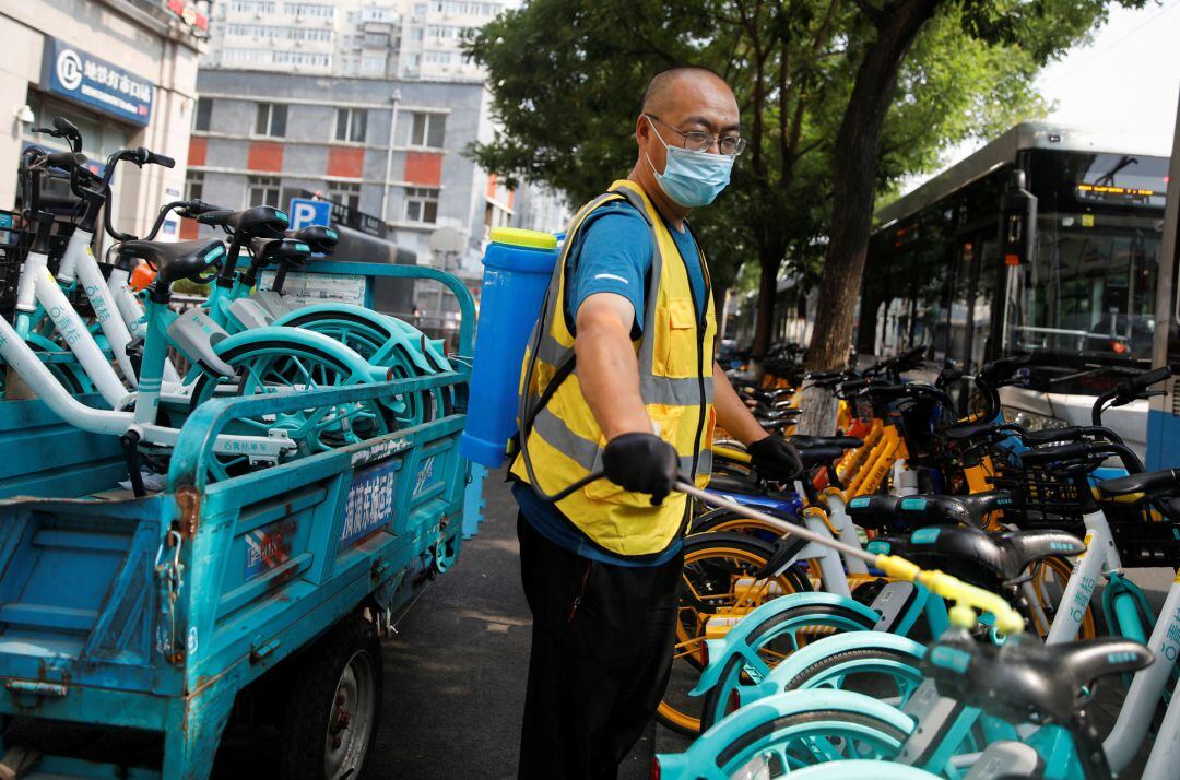 Un hombre desinfecta bicicletas en China.