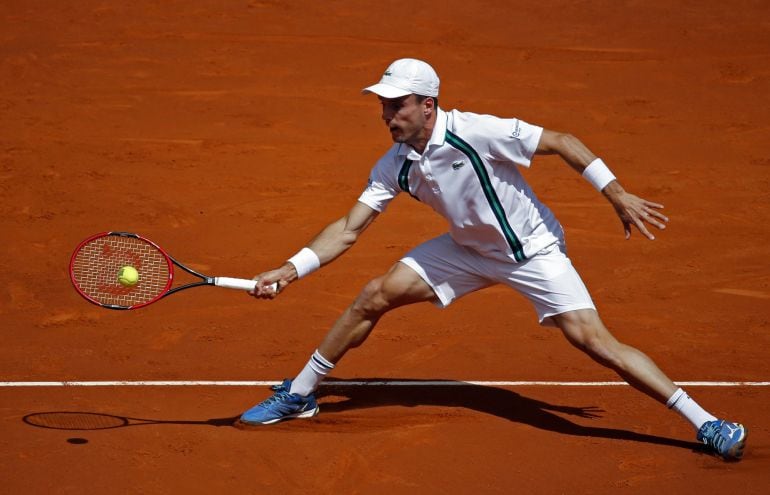 El tenista español Roberto Bautista, golpea la bola ante el también español Feliciano López, durante el partido de segunda ronda del abierto de tenis Mutua Madrid Open que se disputa en la Caja Mágica.