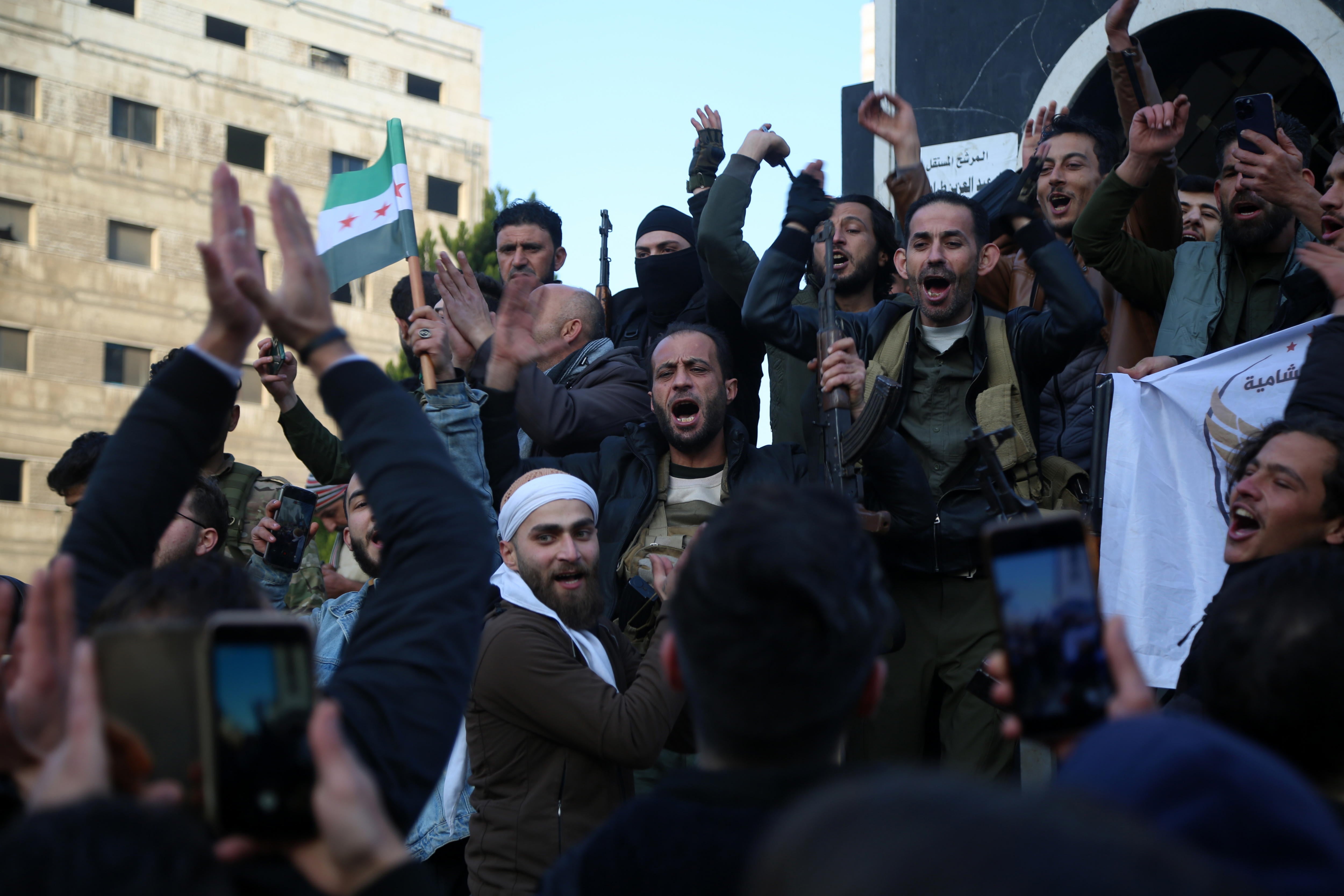 Varias personas celebran en la ciudad de Homs la caída del régimen de Al Asad en Siria