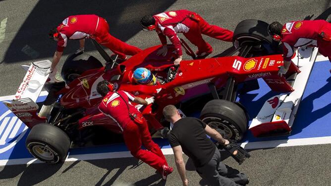 El piloto español Fernando Alonso, del equipo Ferrari, es remolcado por sus mecánicos en el &#039;pit-lane&#039; del circuito de Cataluña, durante la segunda jornada de la última tanda de entrenamientos que las escuderías realizan antes del inicio del Mundial de Fó