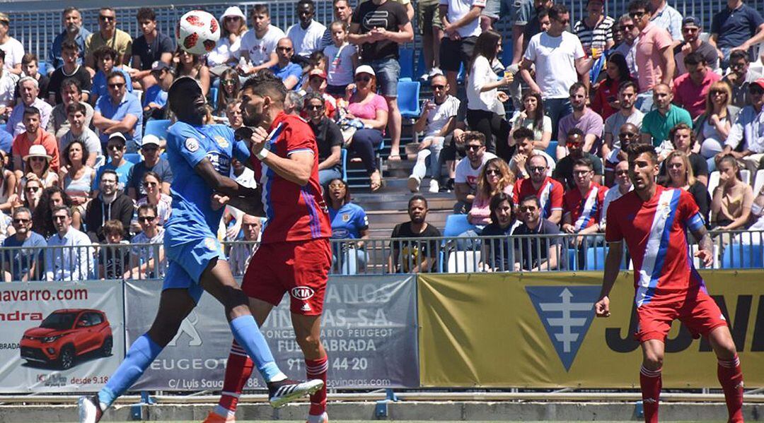 El jugador del C.F. Fuenlabrada Randy Nteka (i) pugna por un balón durante el encuentro de ida de la eliminatoria por el ascenso ante el R.C. Recreativo de Huelva.