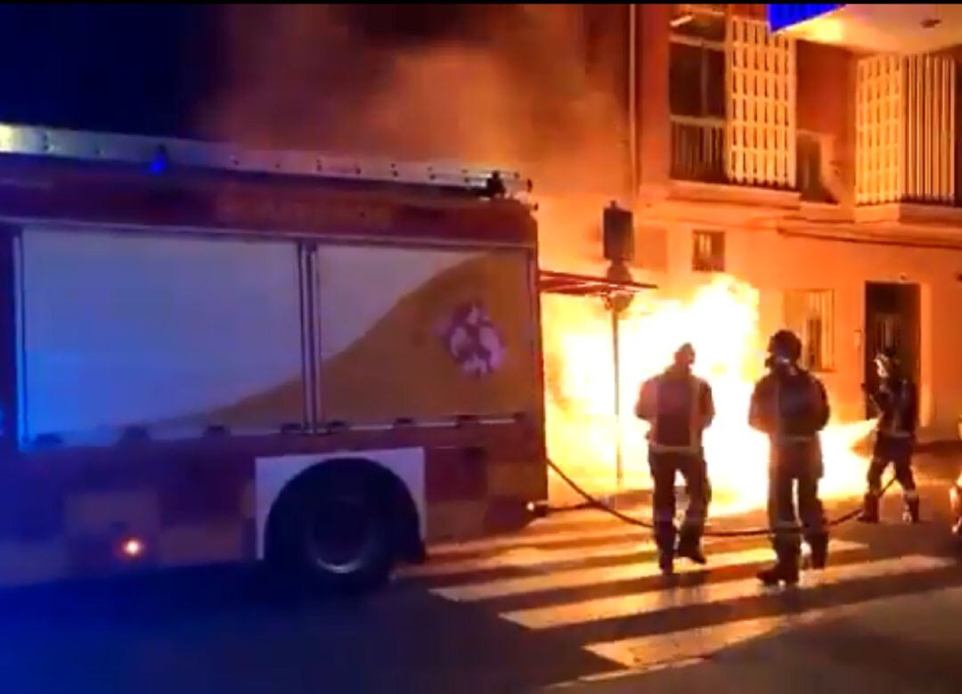 Los bomberos apagan un contenedor incendiado en la zona sur de la capital