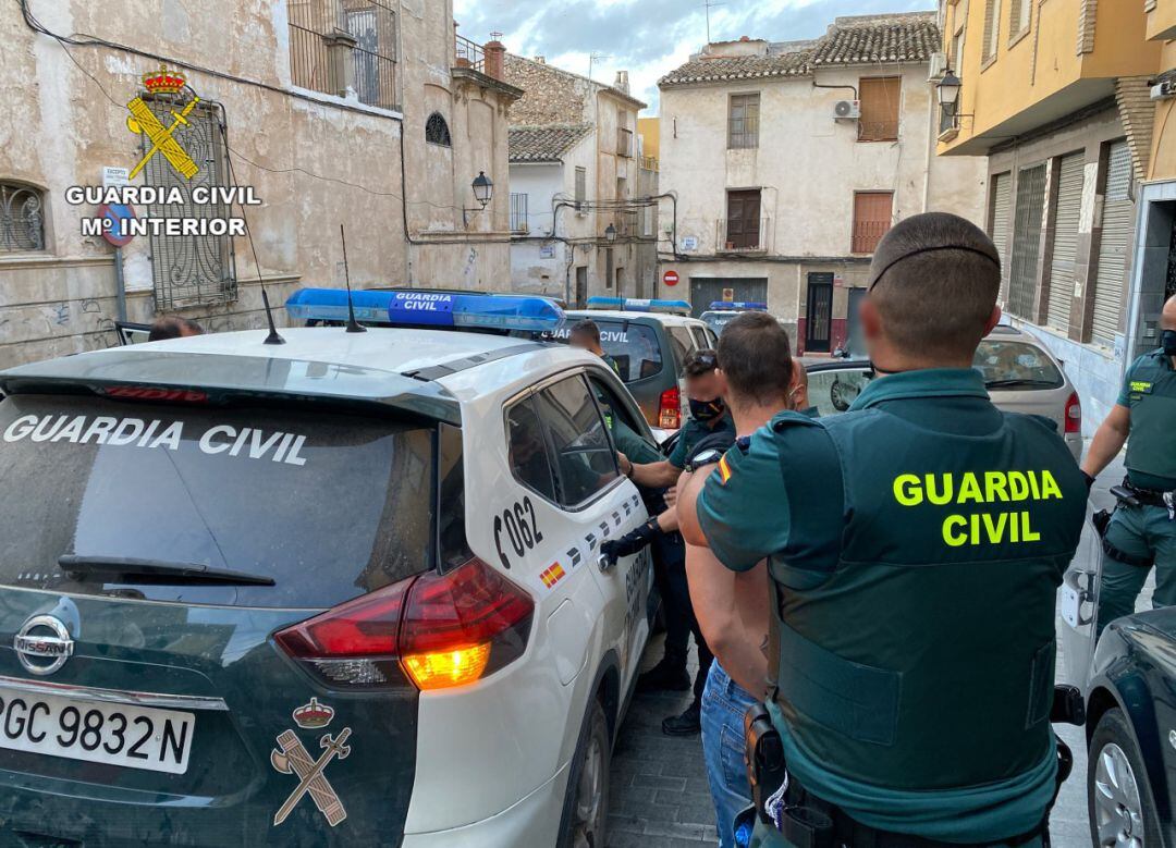 Agentes de la Guardia Civil trasladan a uno de los detenidos