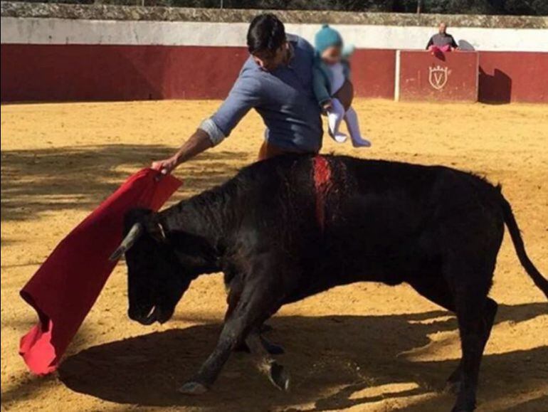 Rivera Ordóñez torea con la mano derecha mientras sostiene a la pequeña Carmen en su brazo izquierdo