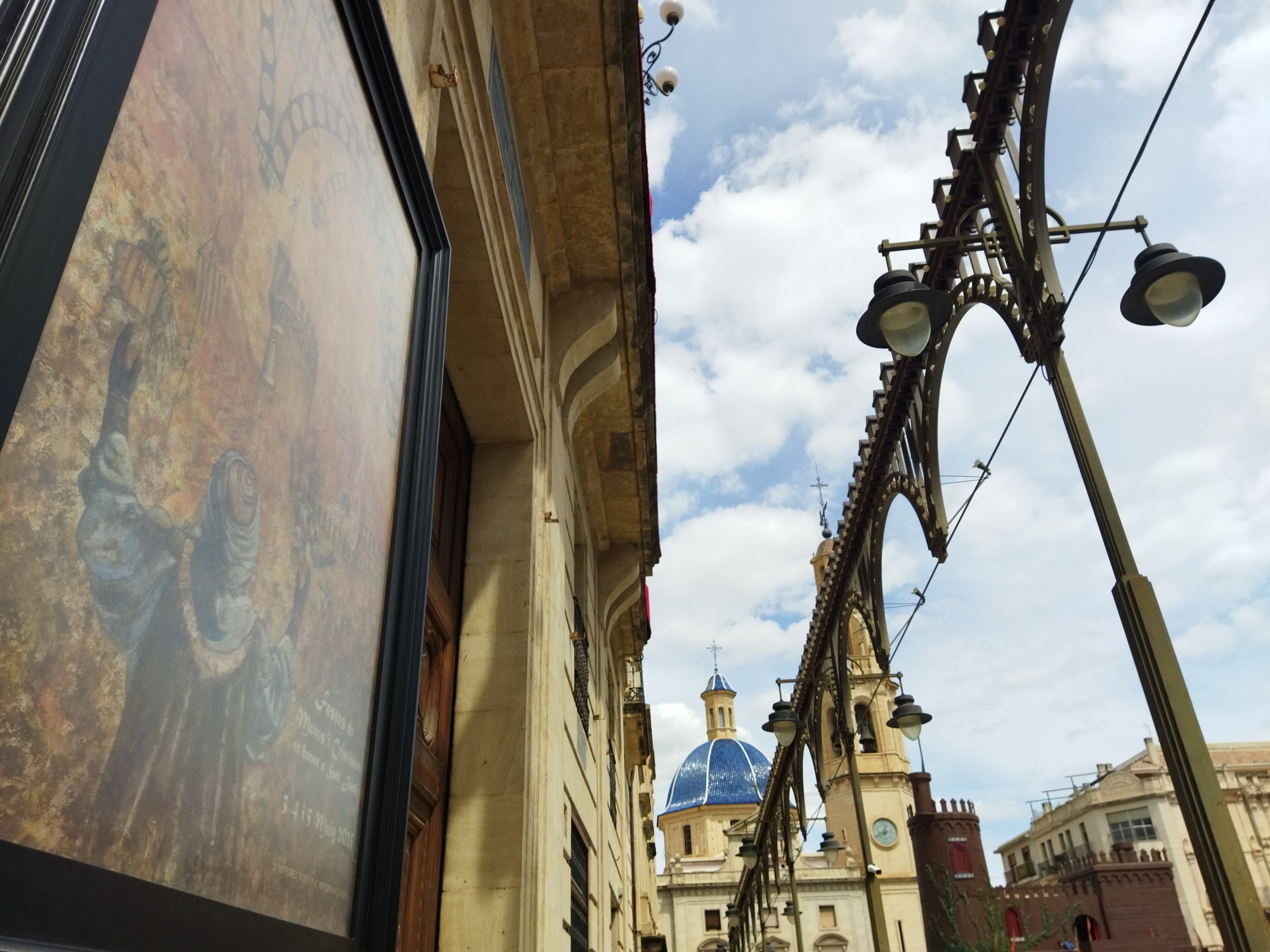 La plaza de España de Alcoy con el cartel y el castillo de las Fiestas de Moros y Cristianos de Alcoy.