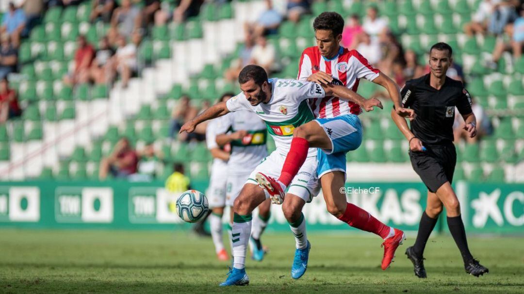 El delantero del Elche Yacine Qasmi protege el balón ante un jugador del Lugo