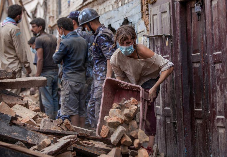 KATHMANDU, NEPAL - APRIL 27:  A foreign volunteer clears debris of a collapsed temple at Basantapur Durbar Square on April 27, 2015 in Kathmandu, Nepal.  