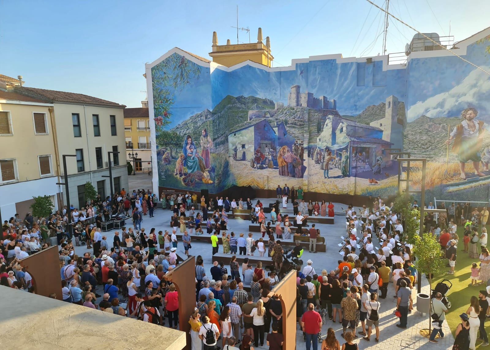 Eldenses frente al mural de grandes dimensiones que simula un día de mercado, que se celebraba en este mismo emplazamiento