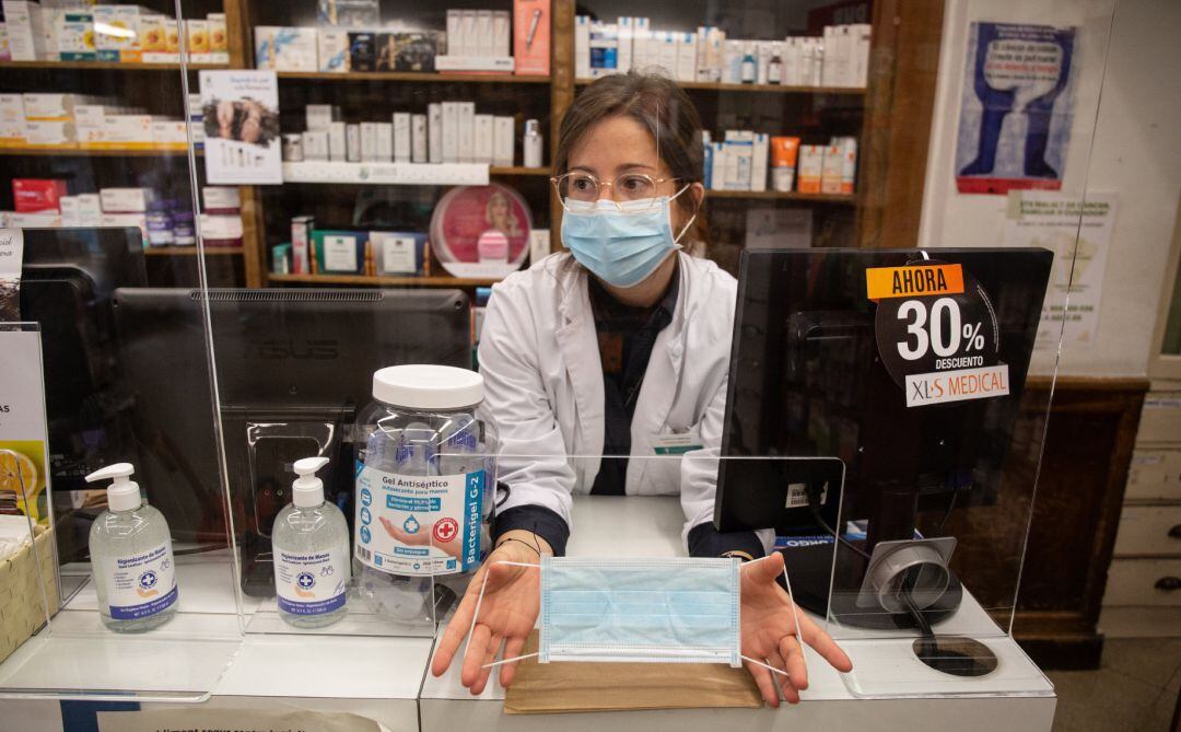 Una farmacéutica muestra una mascarilla.