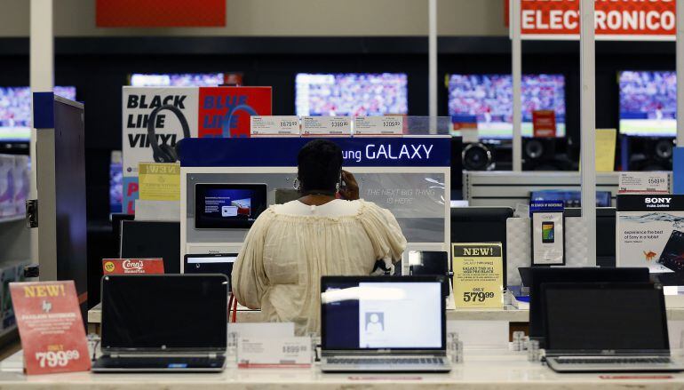 Una mujer observa los últimos modelos de teléfonos en una tienda de tecnología